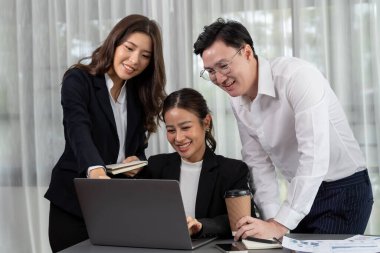 Harmony in office concept as business people analyzing dashboard paper together in workplace. Young colleagues give ideas at manager desk for discussion or strategy planning about project.