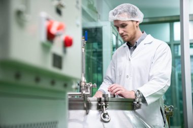 Bir bilim adamının portresi, eczacı laboratuarda bilimsel ekipman kullanarak kenevir yağı çıkarıyor. Alternatif tıbbi tedavi için esrar çıkarma kavramı
