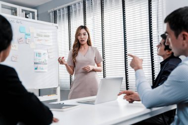 Competent office workers from various nationalities are debating, discussing and brainstorming in the meeting room. A group of employees is collaborating to achieve their business objectives.