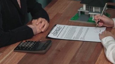 İş kadını ofiste başarılı bir iş anlaşması yaptıktan sonra sözleşme imzaladı. Hevesli müşteri el yazısı resmi kredi, gayrimenkul veya yatırım sözleşmesi belgesine imza atıyor.