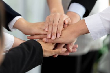 Top view closeup business team of suit-clad businesspeople join hand stack together. Colleague collaborate and work together to promote harmony and teamwork concept in office workplace.