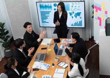 Top widen view of confidence of company presentation on financial analyzed by business intelligence in dashboard report with businesspeople in boardroom meeting to promote harmony in workplace concept