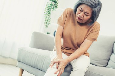 An agonizing elderly woman is experiencing chest pain. Medical attention, medical service for seniors.