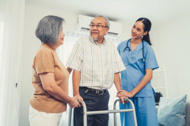 Contented senior man was helped on folding walking by his wife and caregiver. Recuperation for elderly, seniors care, nursing home.