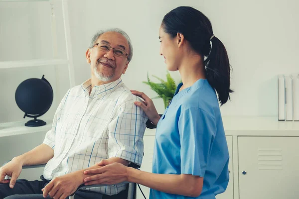 Happy Positive Asian Nurse Giving Support Touching Contented Senior Man — Stok fotoğraf