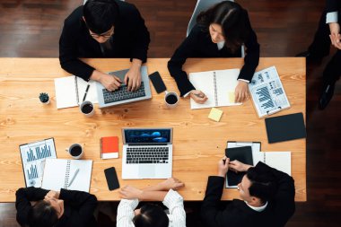Top view manager or office worker give presentation in harmony conference room to business colleague, BI data dashboard on screen and pile of financial analyzed data reports on meeting table.