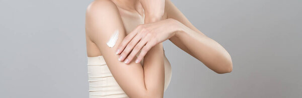 Closeup glamorous woman applying moisturizer cream on her arm for perfect skincare treatment in isolated background. Soft makeup young girl portrait with skin rejuvenation and cosmetology concept.