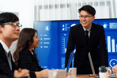 Confidence and asian businessman give presentation on financial analyzed by business intelligence in dashboard report to other people in board room meeting to promote harmony in workplace.