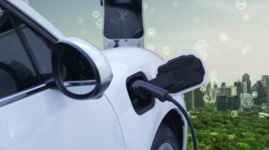 Gelişmiş yeşil şehir ESG sembolü elektrikli araçla arka plan, EV araba şarj noktasındaki enerji yenilenebilir enerji taşımacılığıyla çevre bilincini artırmak için şarj ediliyor.