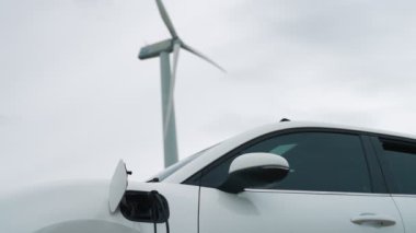 Çevreyi korumak için rüzgar türbininden yeşil ve yenilenebilir enerjiyle çalışan şarj istasyonunda şarj edilen gelişmiş gelecek enerji altyapısı konsepti.