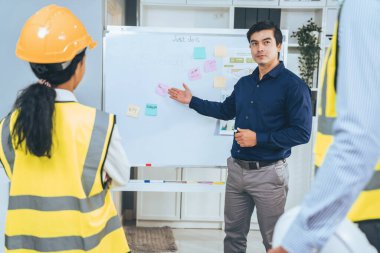 A team of investor and competent engineers brainstorming on the whiteboard to find new ideas and making plans. The idea of a team gather ideas together.