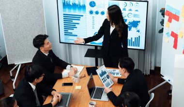 Top widen view of confidence of company presentation on financial analyzed by business intelligence in dashboard report with businesspeople in boardroom meeting to promote harmony in workplace concept