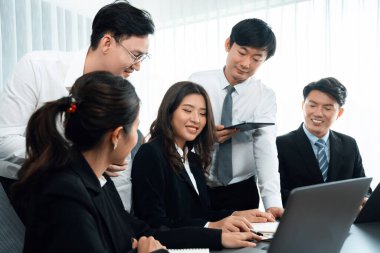 Harmony in office concept as business people analyzing dashboard paper together in workplace. Young colleagues give ideas at manager desk for discussion or strategy planning about project.