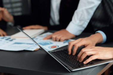 Business team analyze business analytic or business intelligence dashboard on laptop screen show graph and chart with statistic in harmony office. Analyst team meeting researching, planning strategy.