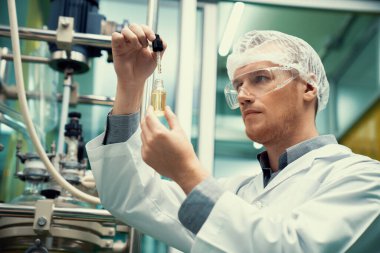 Bir bilim adamı ya da eczacı CBD kenevir yağını laboratuarda tıbbi amaçlar için çıkartıyor. Esrar çıkarma makinesinden üretilen alternatif esrar temelli ilaçlar.