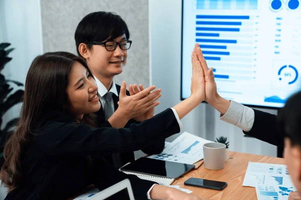 Happy business team office worker making high five with each other and celebrate after successful meeting in office workplace, business agreement to promote harmony and strong teamwork concept.