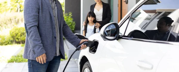 Progressive Young Parents Daughter Electric Vehicle Home Charging Station Green — 图库照片