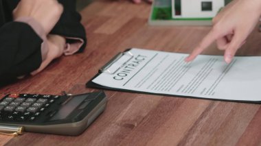 Gayretli emlak acentesi müşteriye bir emlak acentesi tarafından tavsiye edilirken, ev kredisi için müşteri sözleşmesi belgelerini sunar..