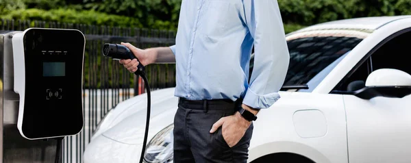 Closeup Progressive Man Holding Charger Plug Public Charging Station Electric —  Fotos de Stock