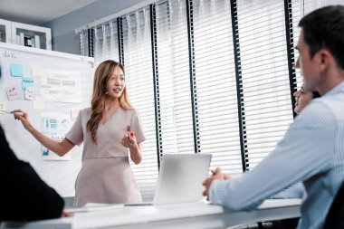 Competent office workers from various nationalities are debating, discussing and brainstorming in the meeting room. A group of employees is collaborating to achieve their business objectives.