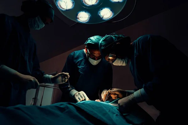 Chirurgický Tým Provádějící Operaci Pacientovi Sterilním Operačním Sále Ordinaci Osvětlené — Stock fotografie