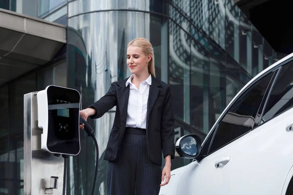 Progressive Businesswoman Wearing Suit Electric Car Recharging Public Parking Car — Stock Fotó