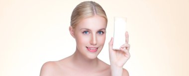 Personable beautiful perfect natural skin woman hold mockup tube moisturizer cream for skincare treatment product advertisement in isolated background with expressive facial and gesture expression.