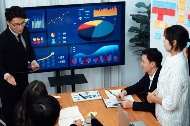 Confidence and asian businessman give presentation on financial analyzed by business intelligence in dashboard report to other people in board room meeting to promote harmony in workplace.