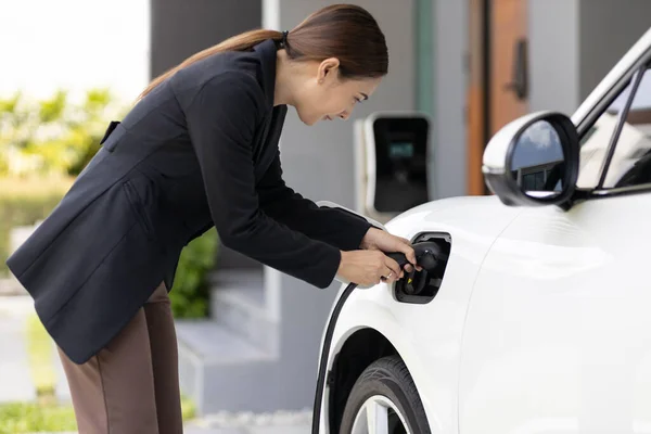 Progressive Woman Install Cable Plug Her Electric Car Home Charging — ストック写真