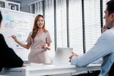 Competent office workers from various nationalities are debating, discussing and brainstorming in the meeting room. A group of employees is collaborating to achieve their business objectives.