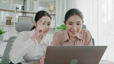 Hevesli ofis çalışanları ofis işyerindeki başarılarını kutluyorlar. Bilgisayarlı bir masada iş birliği yapan ve başarı elde eden meslektaşlar. İki iş kadını işlerinden memnun..