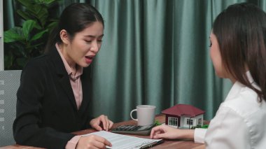 Gayretli emlak acentesi müşteriye bir emlak acentesi tarafından tavsiye edilirken, ev kredisi için müşteri sözleşmesi belgelerini sunar..