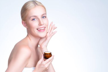 Personable beautiful perfect clean skin soft makeup woman finger applying moisturizer cream on her face for anti aging wrinkle. Facial rejuvenation with expressive hand gesture putting cream.