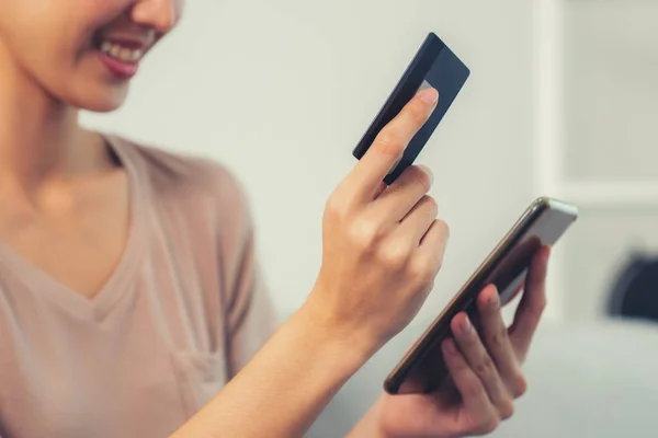 stock image Contented young woman eagerly makes an online purchase using her smartphone. E-commerce business, online purchasing.