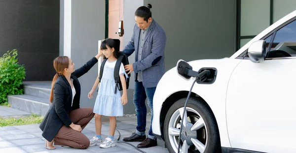 Progressive Young Parents Daughter Electric Vehicle Home Charging Station Green — ストック写真