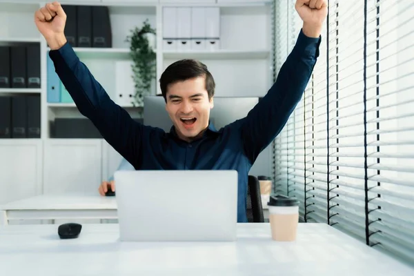 Young male employee receives a promotion, good news or finished his task and overjoyed for being a competent worker. Idea of promotion in career, reward for working hard worker.
