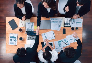 Top-view business team of financial data analysis meeting with business intelligence, report paper and dashboard on laptop for marketing strategy. Business people working together in office of harmony