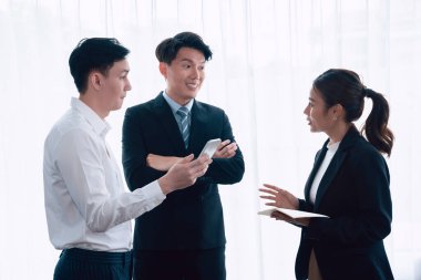 Mentor, manager advice younger colleagues in workplace. Businesspeople discussing or planning financial project strategy, talking together for harmony and strong teamwork in office concept.