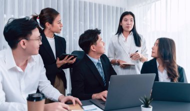 Harmony in office concept as business people analyzing dashboard paper together in workplace. Young colleagues give ideas at manager desk for discussion or strategy planning about project.