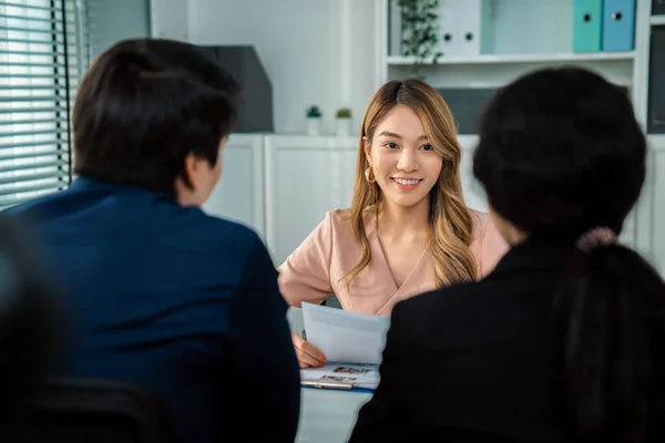A young female asian candidate tries to impress her interviewer by being competent. International company, multicultural environment in workplace.