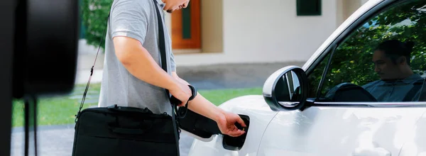 Progressive Asian Man Install Cable Plug His Electric Car Home — Stok fotoğraf