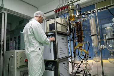 Bilim adamı ya da eczacı tıbbi ve sağlık hizmetleri için kenevir yağı çıkarıyor. Esrar ürünlerinden alınan sağlık hizmetleri eczanesi. Cam tüpler ve teçhizatlı kenevir yağı çıkarma makinesi.