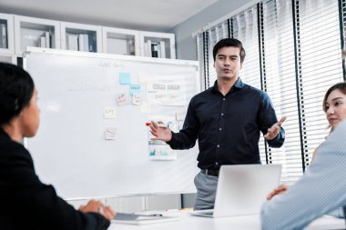 Competent office workers from various nationalities are debating, discussing and brainstorming in the meeting room. A group of employees is collaborating to achieve their business objectives.