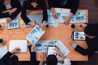 Top-view business team of financial data analysis meeting with business intelligence, report paper and dashboard on laptop for marketing strategy. Business people working together in office of harmony