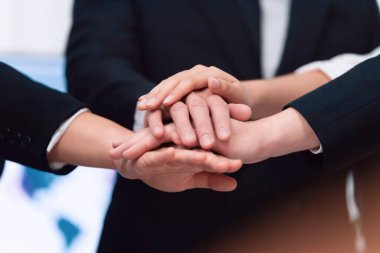 Top view closeup business team of suit-clad businesspeople join hand stack together. Colleague collaborate and work together to promote harmony and teamwork concept in office workplace.