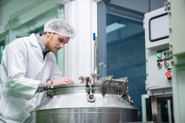 Bir bilim adamının portresi, eczacı laboratuarda bilimsel ekipman kullanarak kenevir yağı çıkarıyor. Alternatif tıbbi tedavi için esrar çıkarma kavramı