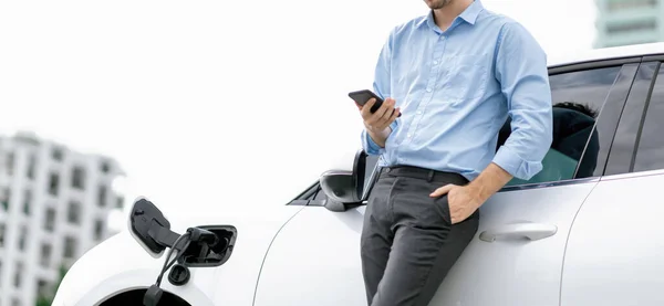 Suit Clad Progressive Businessman Look Cars Battery Status His Phone — Stockfoto