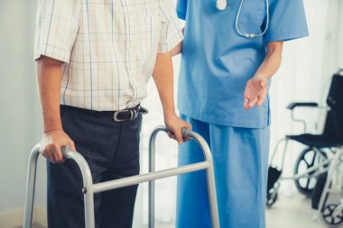 Physiotherapist assists her contented senior patient on folding walker. Recuperation for elderly, seniors care, nursing home.