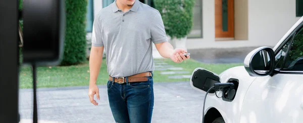 Progressive Asian Man Install Cable Plug His Electric Car Home — Stockfoto