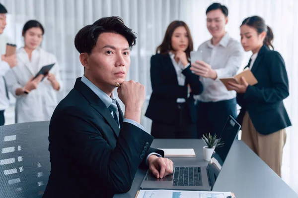 stock image Portrait of focus young successful confident male manager, executive wearing business wear in harmony office arm crossed with blurred meeting background of colleagues, office worker.